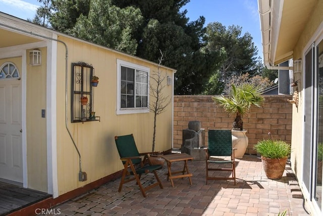 view of patio featuring an outdoor structure and fence