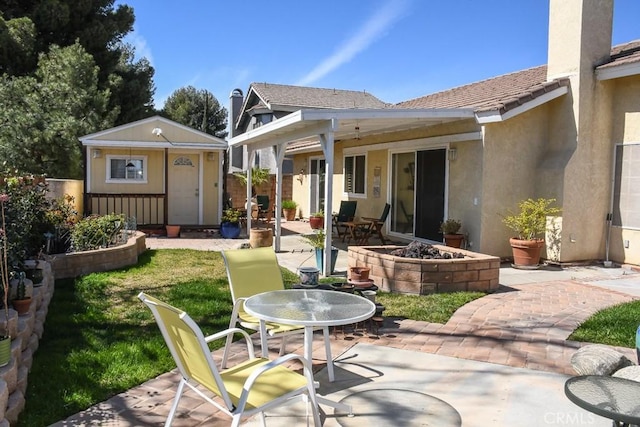 view of patio / terrace with a storage unit, outdoor dining space, a fire pit, and an outdoor structure