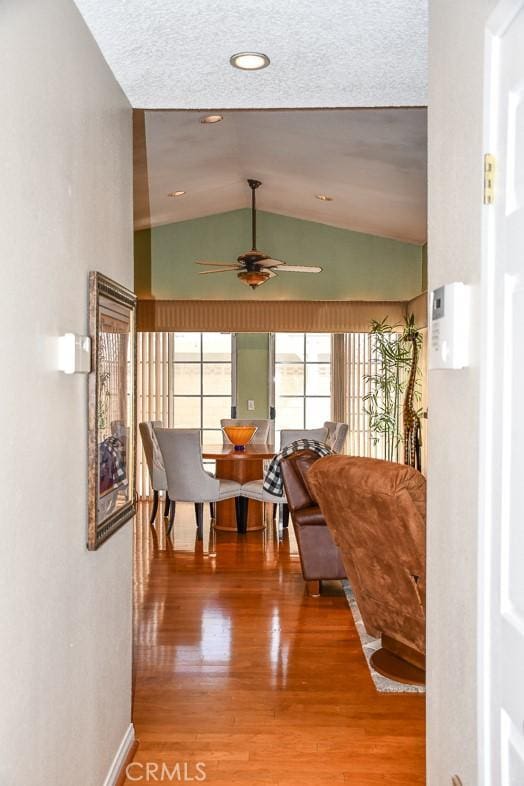 interior space with vaulted ceiling, wood finished floors, and baseboards