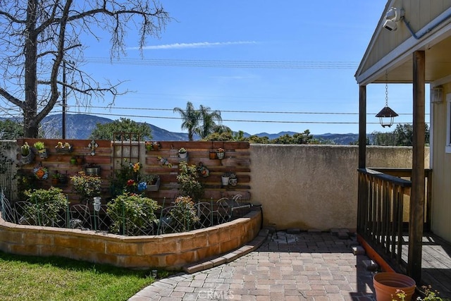 view of patio / terrace featuring a mountain view and fence