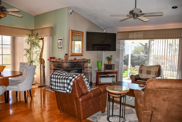 living area featuring ceiling fan, a fireplace, lofted ceiling, and wood finished floors