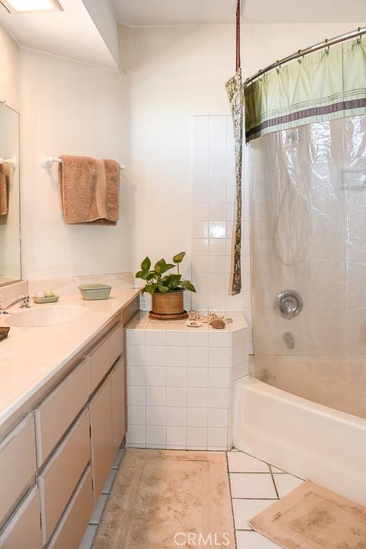 full bath with tile patterned flooring, vanity, and shower / bath combo