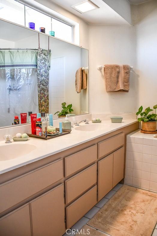 bathroom with double vanity, tile patterned floors, and a sink