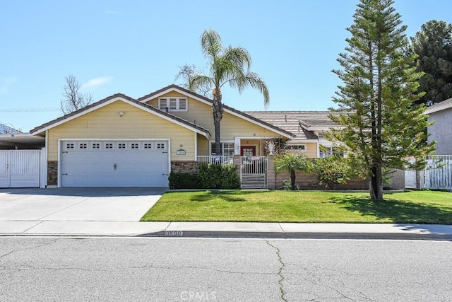 view of front of house featuring fence, driveway, a front lawn, stone siding, and a garage