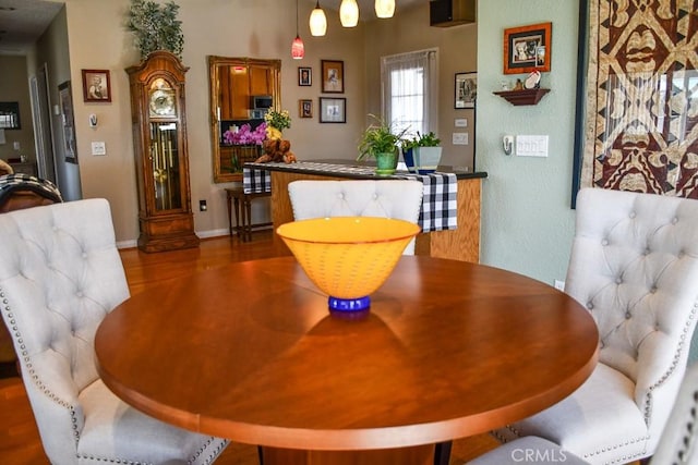 dining room featuring wood finished floors and baseboards