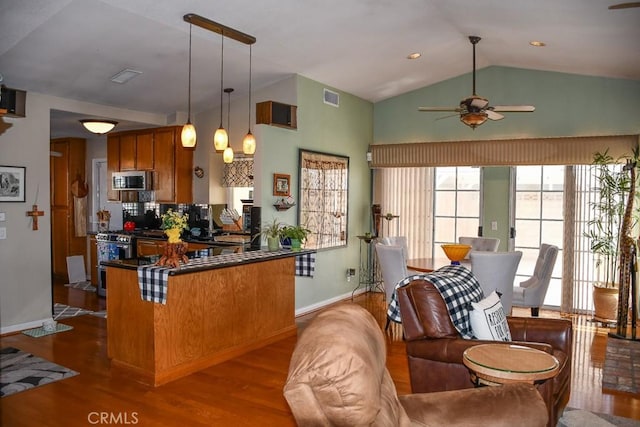 kitchen with dark wood-type flooring, brown cabinetry, visible vents, and stainless steel appliances