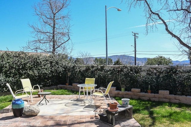 view of patio / terrace featuring a mountain view and a fenced backyard