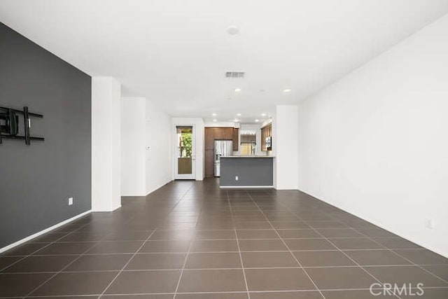 unfurnished living room with visible vents, recessed lighting, and dark tile patterned flooring