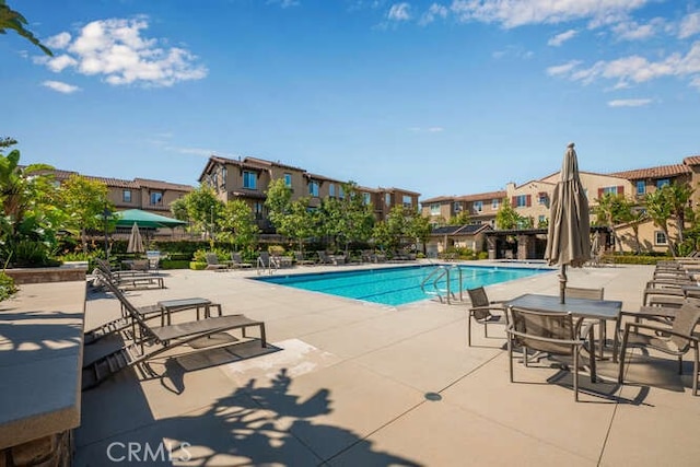 pool with a residential view and a patio area