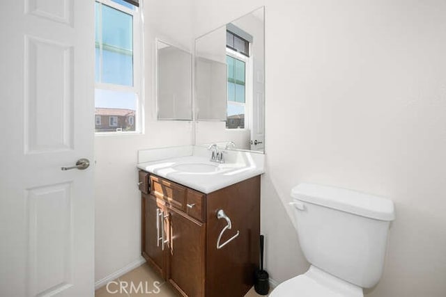 half bathroom with vanity and toilet