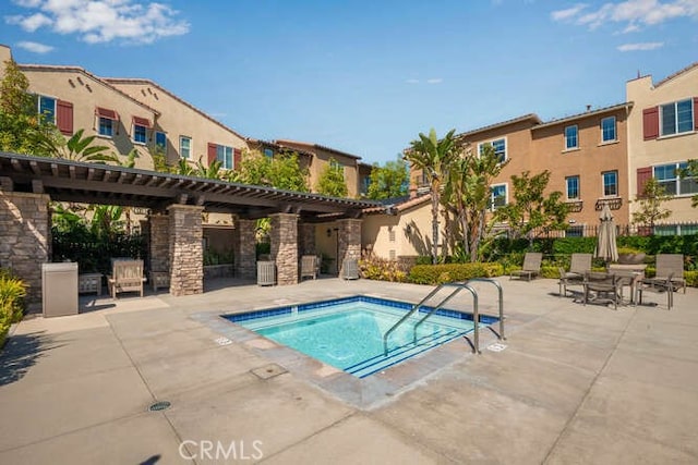 view of swimming pool with a hot tub and a patio