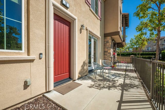 doorway to property with french doors, stone siding, and stucco siding