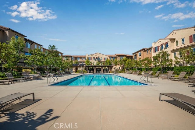 pool featuring a patio and a residential view