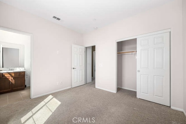 unfurnished bedroom featuring baseboards, visible vents, light carpet, and a closet