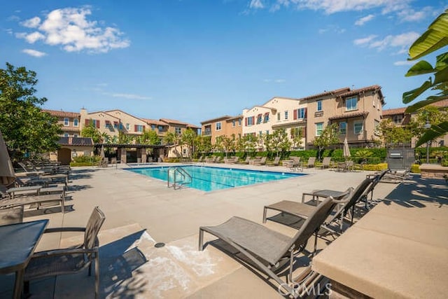 community pool featuring a residential view and a patio