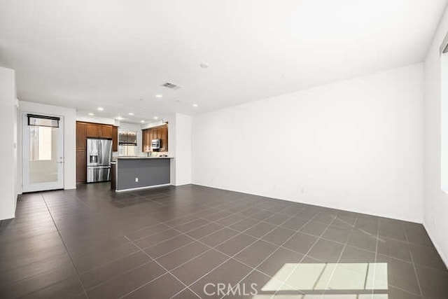 unfurnished living room featuring visible vents, recessed lighting, and dark tile patterned flooring