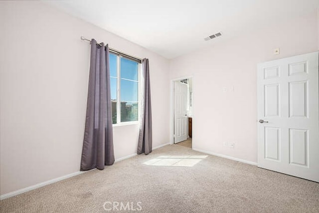 carpeted empty room with visible vents and baseboards