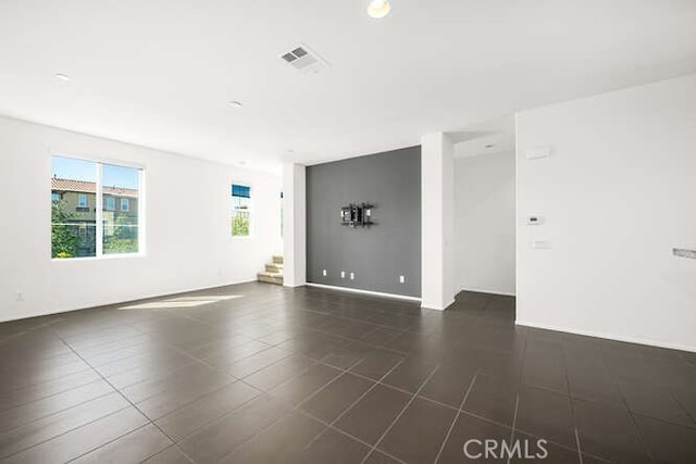 unfurnished room featuring stairway, baseboards, and visible vents