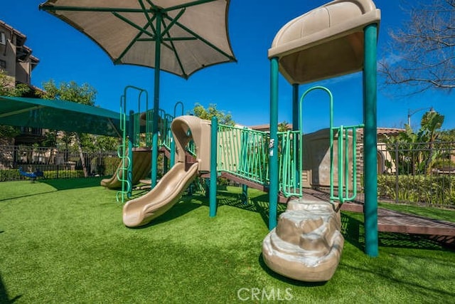 community jungle gym with a lawn and fence