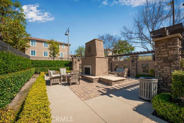 view of patio / terrace with exterior fireplace and fence