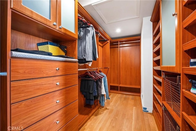 spacious closet with light wood-type flooring and attic access