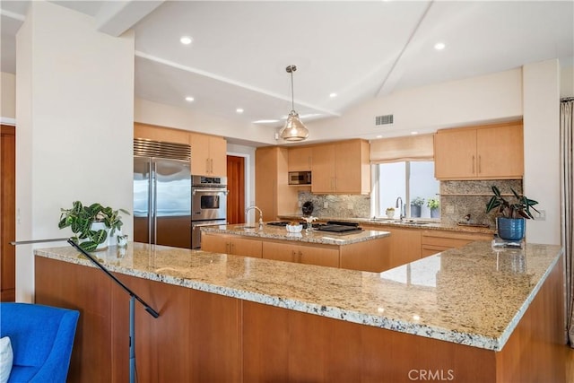 kitchen with visible vents, a peninsula, a sink, appliances with stainless steel finishes, and backsplash