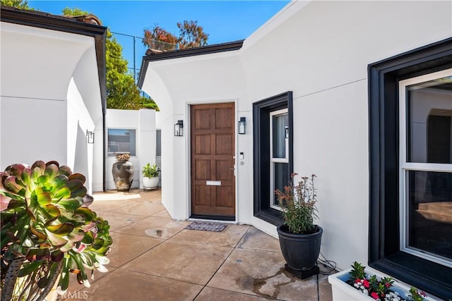 view of exterior entry featuring stucco siding