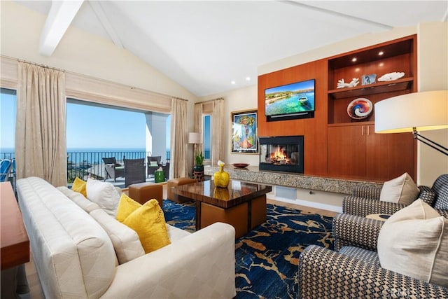 living room featuring a glass covered fireplace, vaulted ceiling, and built in shelves