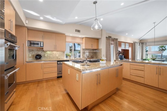 kitchen featuring visible vents, a kitchen island, light brown cabinetry, lofted ceiling with beams, and stainless steel appliances