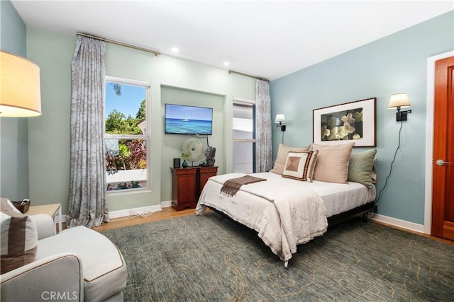 bedroom with recessed lighting, wood finished floors, and baseboards