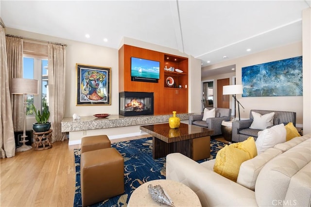 living room featuring recessed lighting, a multi sided fireplace, wood finished floors, and vaulted ceiling