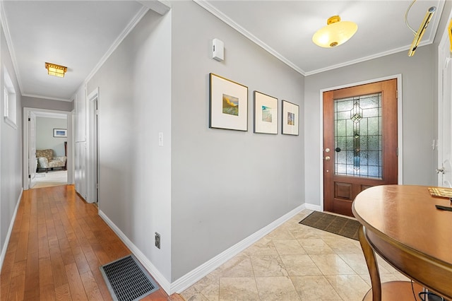 entrance foyer with visible vents, baseboards, and ornamental molding