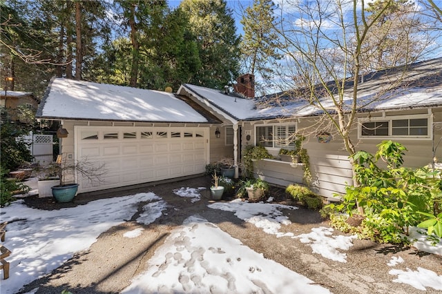 single story home featuring a chimney and a garage