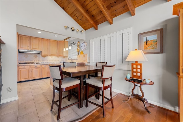 dining room with light tile patterned floors, baseboards, beam ceiling, and wooden ceiling