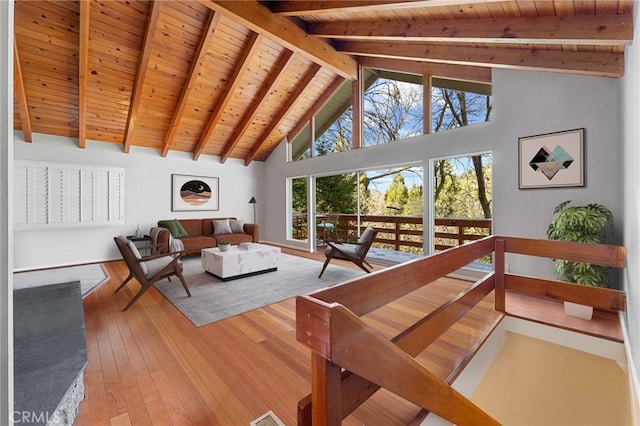 living room featuring beam ceiling, wooden ceiling, high vaulted ceiling, and light wood-style floors