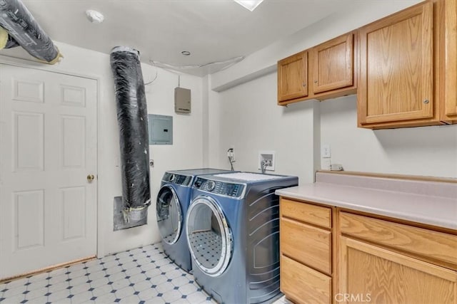 clothes washing area featuring washer and dryer, cabinet space, electric panel, and light floors