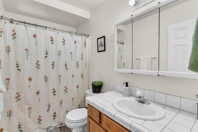 bathroom featuring vanity, curtained shower, and toilet