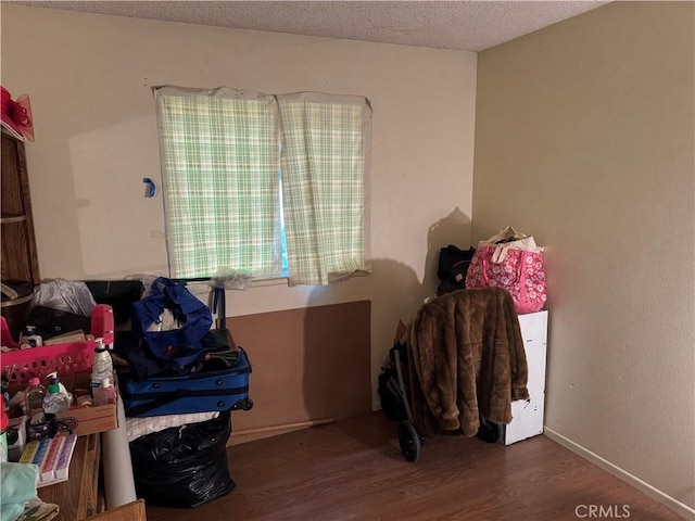 miscellaneous room featuring wood finished floors and a textured ceiling