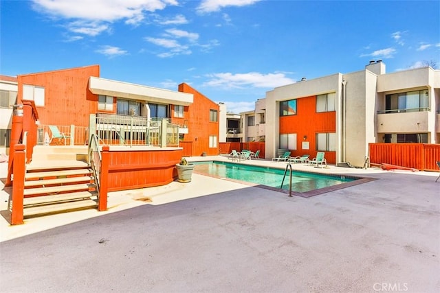 pool with a patio area and fence