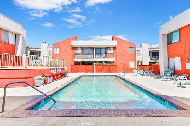 pool with a patio and fence