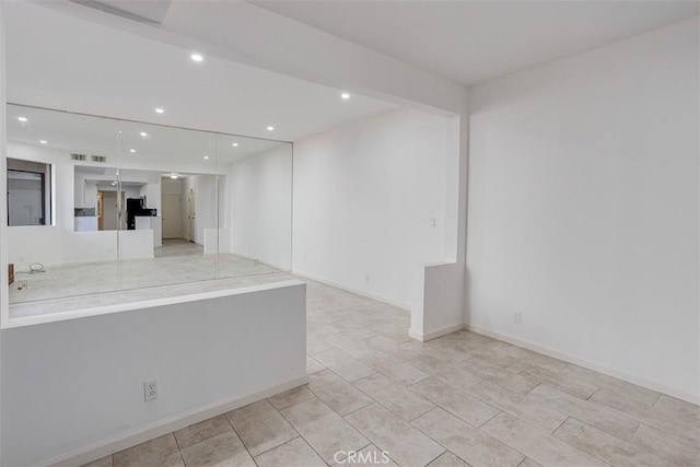 empty room featuring visible vents, recessed lighting, and baseboards