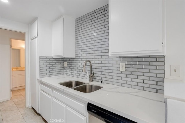 kitchen featuring white cabinets, light tile patterned floors, tasteful backsplash, and a sink