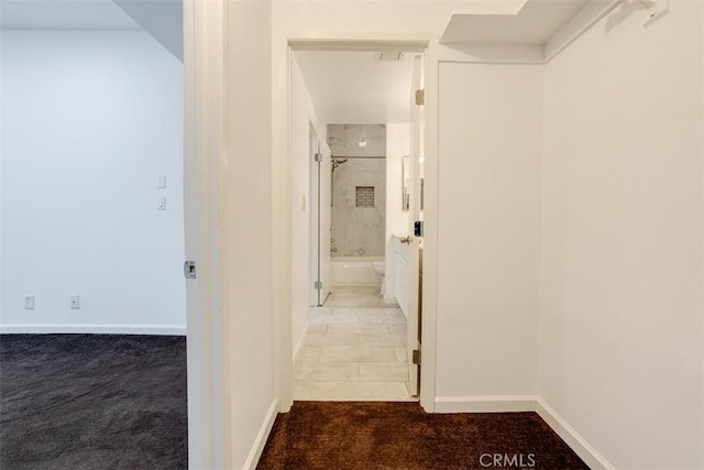 hall featuring baseboards and carpet floors