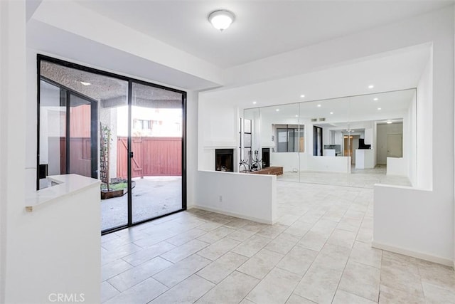 interior space featuring recessed lighting, a fireplace, baseboards, and light tile patterned flooring