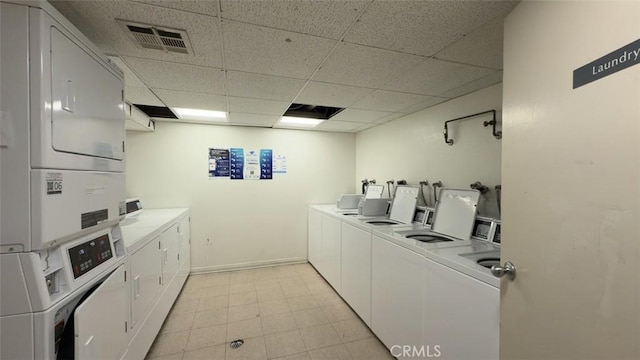 shared laundry area with washer and clothes dryer, visible vents, stacked washer / drying machine, and baseboards