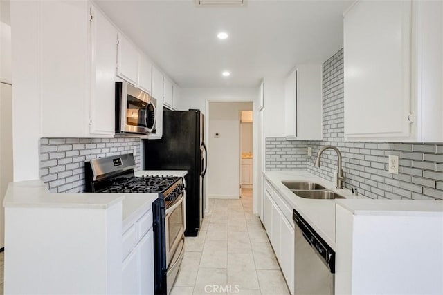 kitchen with a sink, stainless steel appliances, white cabinets, and light countertops