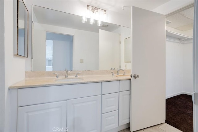 bathroom featuring double vanity, tile patterned floors, and a sink