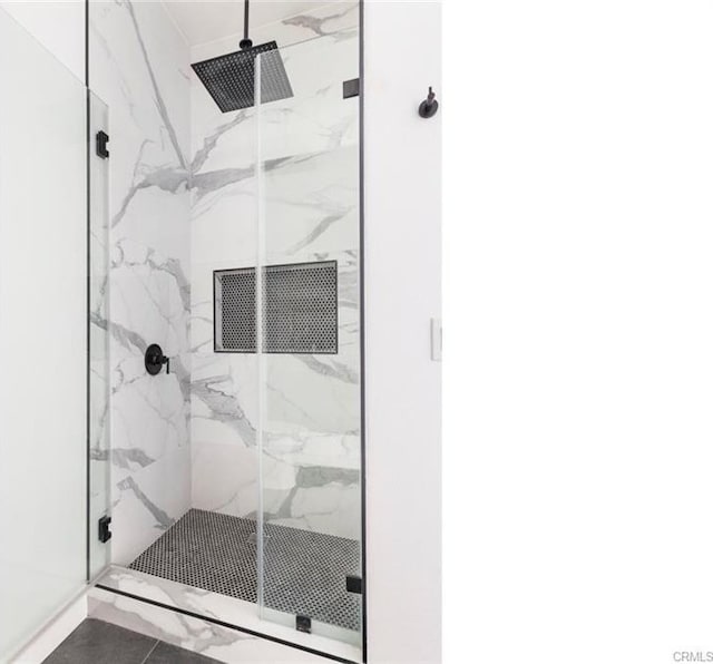 bathroom featuring a marble finish shower