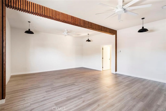 spare room with baseboards, ceiling fan, and wood finished floors