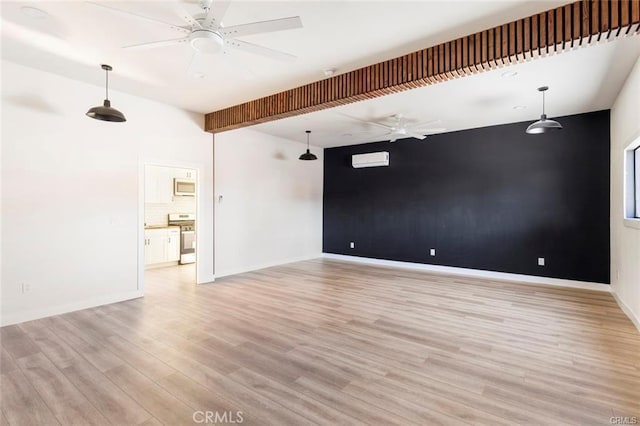 unfurnished room with light wood-style flooring, baseboards, an accent wall, and ceiling fan